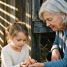 A grandmother and grand-daughter collecting eggs.