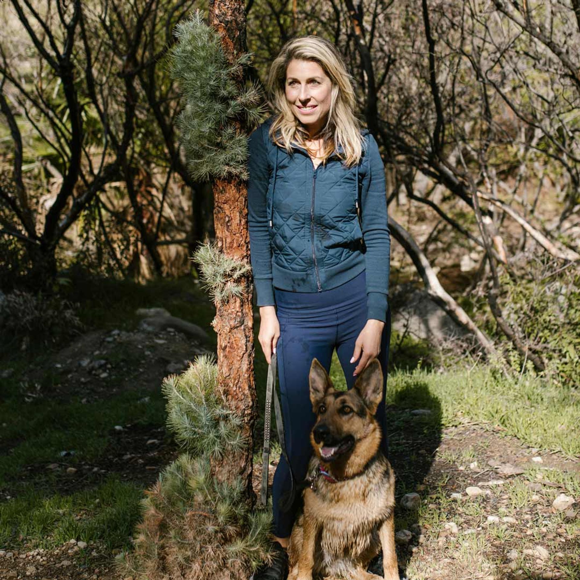 Woman hiking with dog in the outdoors.
