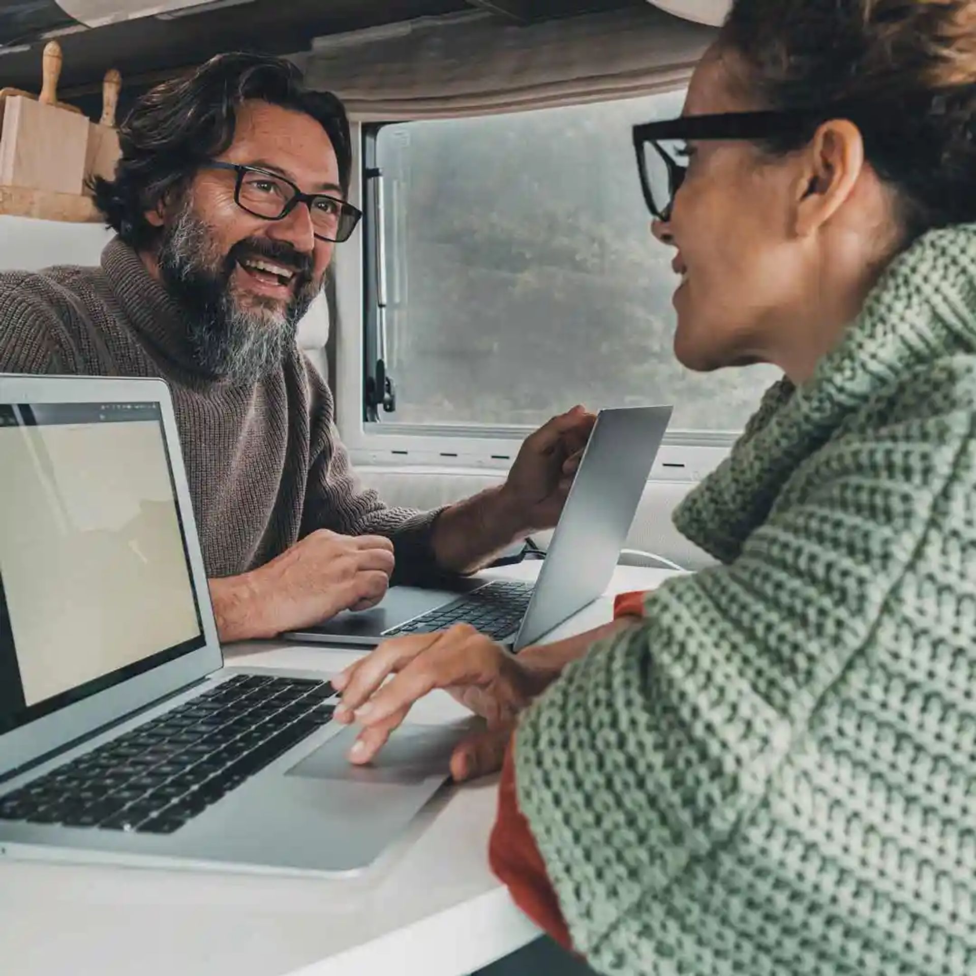 Couple working on their laptops inside their RV. 