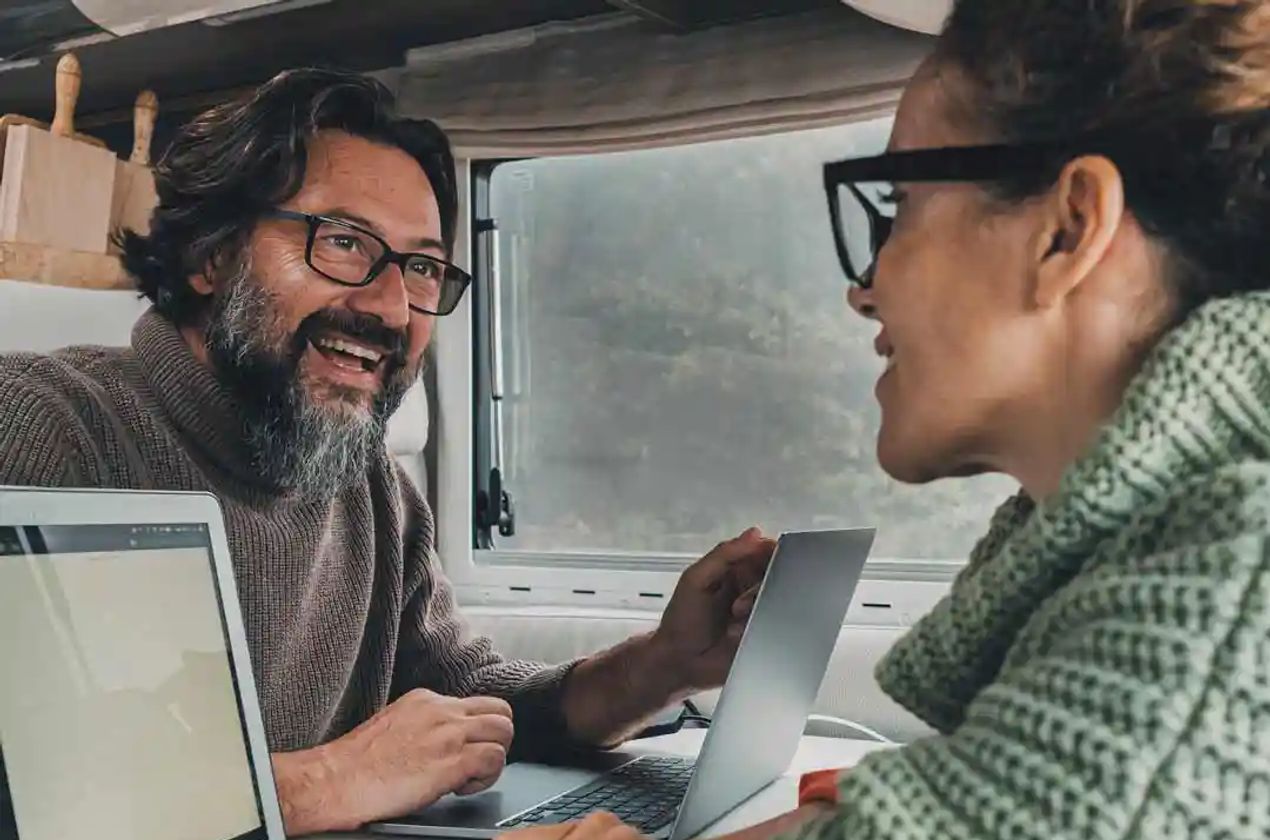 Couple working on their laptops inside their RV.