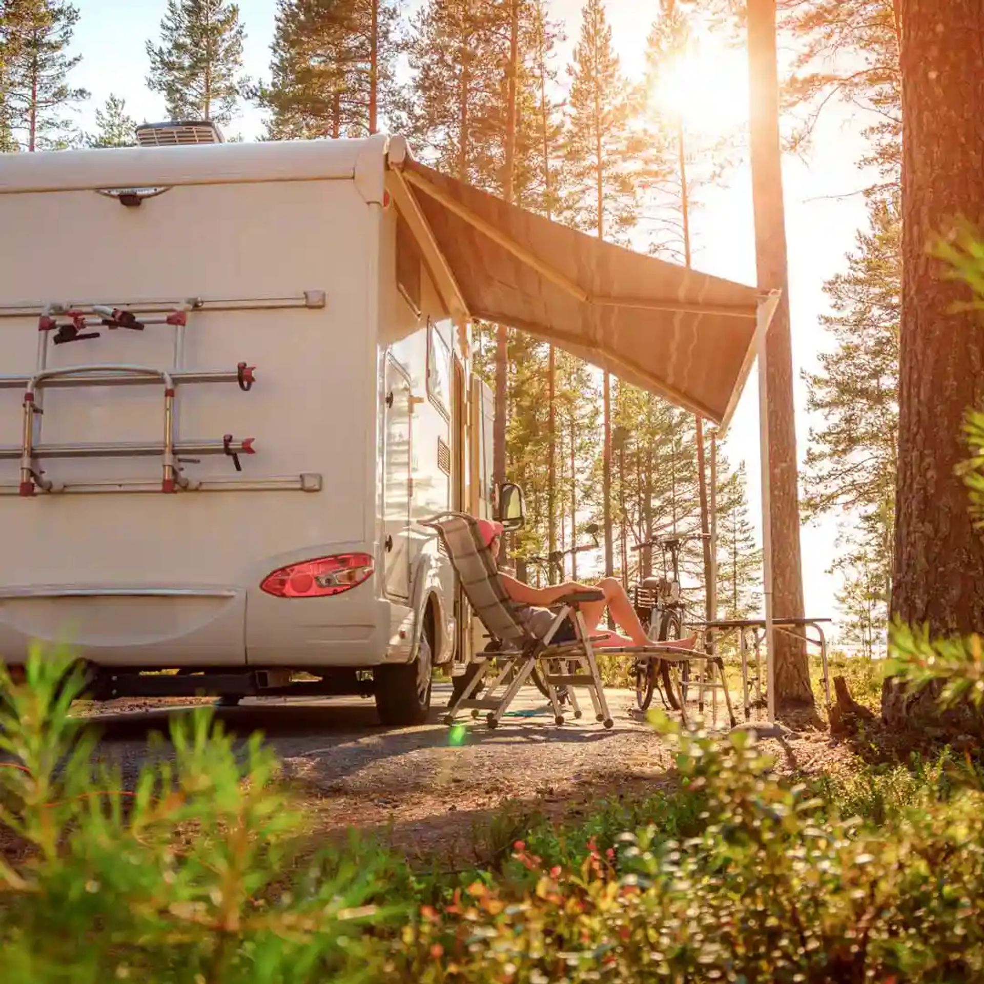 Lady enjoying her RV camping in a wooded area.
