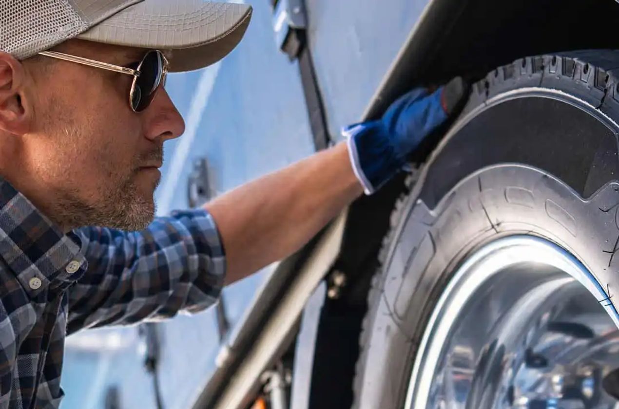 Man checking the tire pressure on his RV